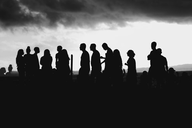 黑白照片中几个人的剪影在日落背景下。图片下载