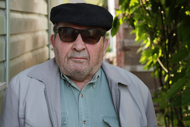 一位戴眼镜的未剃须老人的头像。图片下载