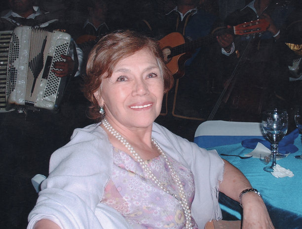 1980年代拍摄的照片，微笑的年长女性在家庭活动中看向镜头摆姿势。图片下载