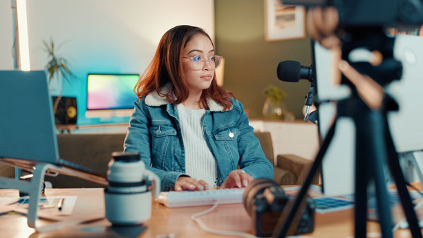 女性，设计师，在家中使用电脑进行照片编辑或内容创作。女性自由职业者或播客主持人，使用科技设备或麦克风进行研究、制作或摄影课程。图片下载
