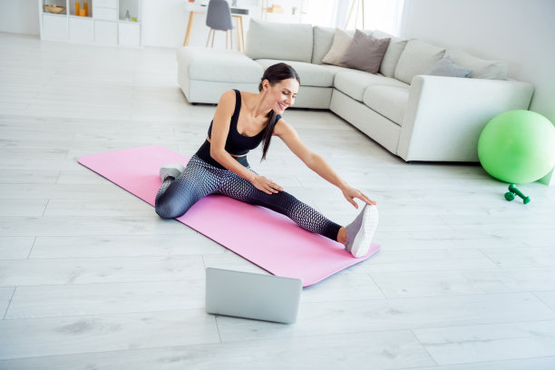年轻迷人的女性在家中练习柔韧性普拉提的全身侧面照片图片下载