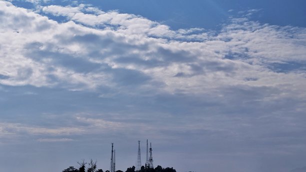 电塔和树的剪影照片，背景是蓝天图片下载