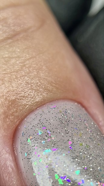 美容院内自然短指甲上的闪光凝胶指甲油特写。干净自然短指甲的极限微距照片。图片下载