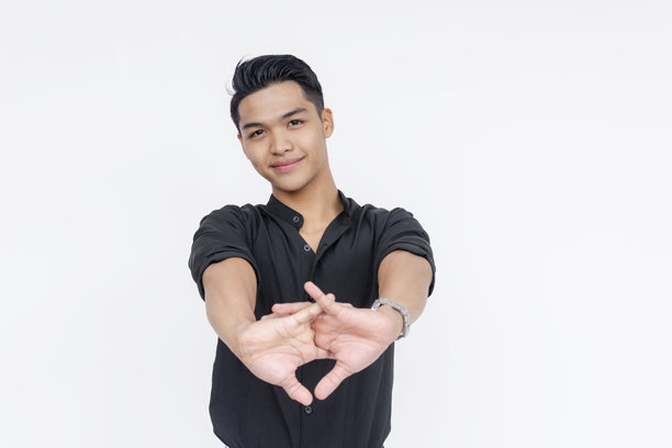 一位友好且英俊的菲律宾男子伸展双臂，准备迎接新的一天。他穿着黑色的 polo 衫和卡其色裤子。全身照片，背景为白色。图片下载