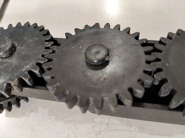 三只黑色机械齿轮并排排列的特写照片图片下载