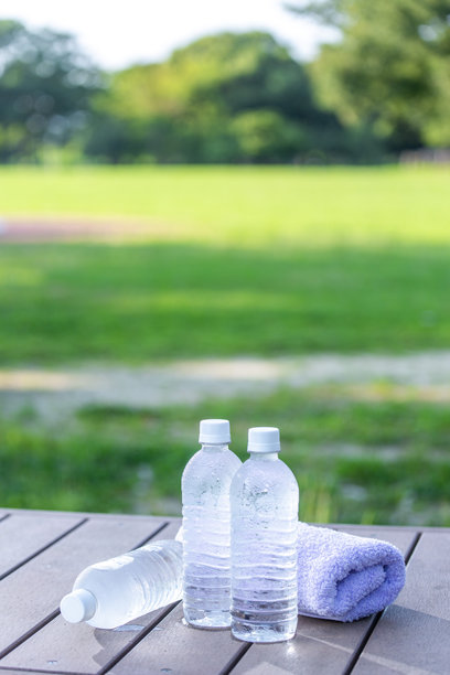 清晨公园里的冷水、矿泉水和桌子，炎热夏季的背景素材，户外场景。图片下载