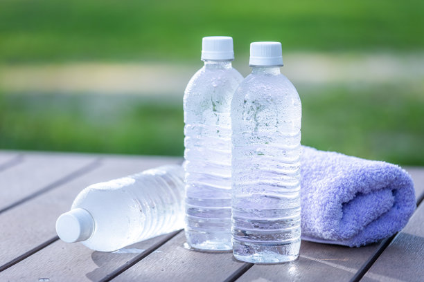 清晨公园里的冷水、矿泉水和桌子，炎热夏季的背景素材，户外场景。图片下载