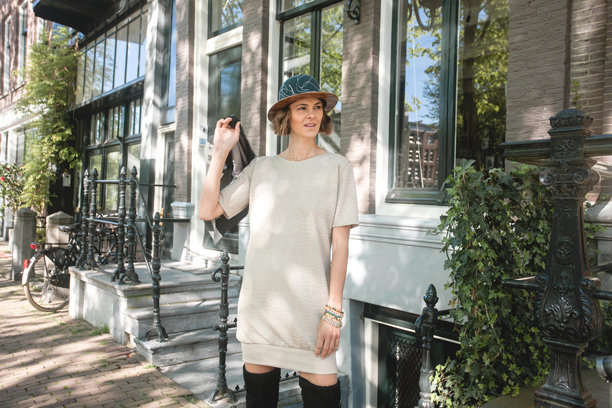 优雅美丽的女性穿着时尚服装，手持夹克在背后，站在阿姆斯特丹典型建筑前的横向照片图片下载