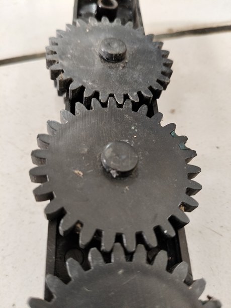 三只黑色机械齿轮并排排列的特写照片图片下载