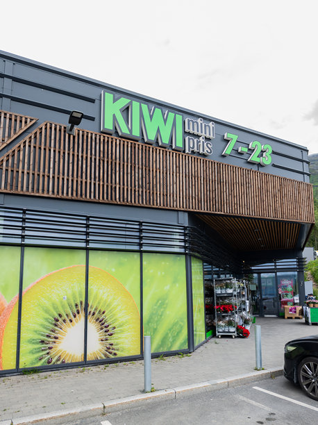 挪威纳尔维克。纳尔维克一家奇异果杂货店的入口。大窗户上装饰着一张奇异果的照片。入口处写着“迷你价格”。图片下载