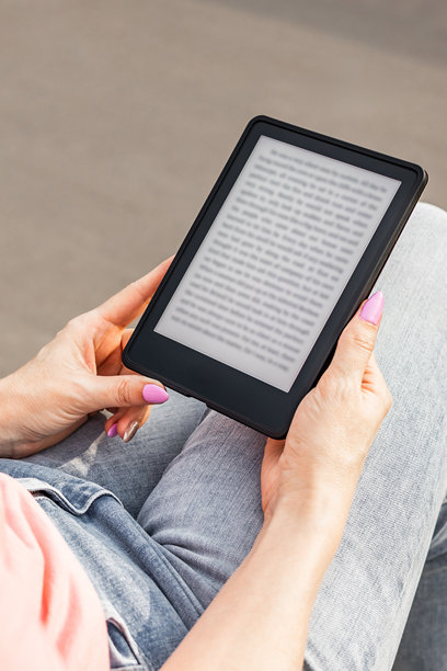 女人坐在长椅上阅读电子书，竖版照片图片下载