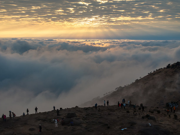 秋晨日出时，云雾在山顶上漂浮的航拍照片图片下载