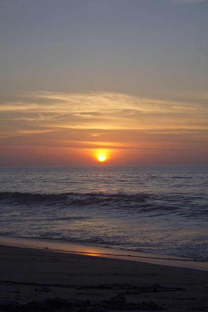 海滩日出垂直照片，天空中有丰富的色彩和留白空间供文字使用图片下载