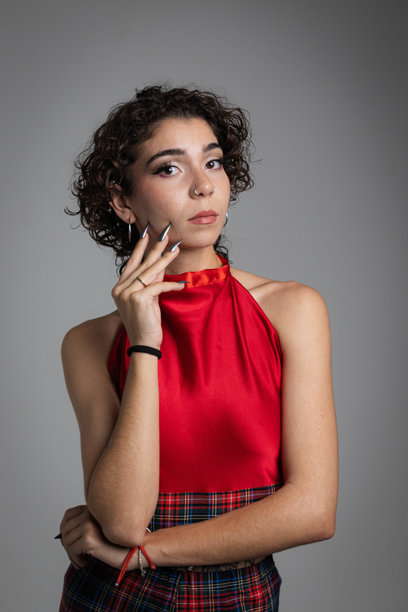 穿着红色裙子的卷发女孩摆姿势的竖版照片图片下载