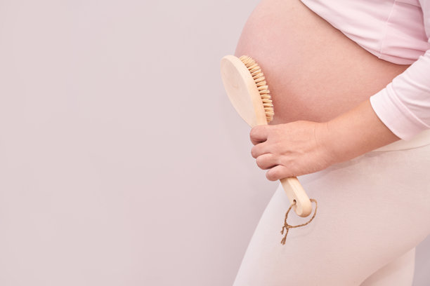 孕妇用身体刷为腹部去角质，进行护肤程序图片下载