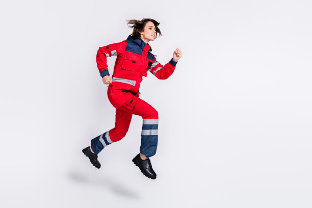 全身照片，乐观的棕发女士穿着制服在灰色背景上奔跑图片下载