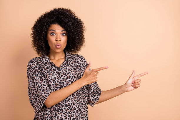 漂亮女孩的照片肖像，惊讶地盯着空白空间，背景为柔和的米色。图片下载