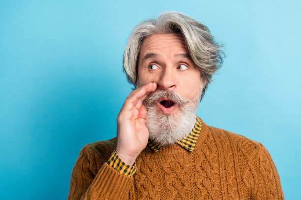 胡子男人的照片肖像，好奇地望着空白空间，背景为鲜艳的蓝色。图片下载