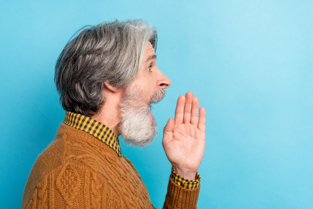 侧面肖像照片，男人在明亮的蓝色背景下大声喊叫，目光投向空白处，传递新闻。图片下载