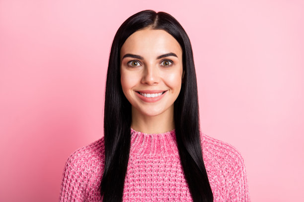 可爱的微笑女孩的照片肖像，背景为柔和的粉色。图片下载