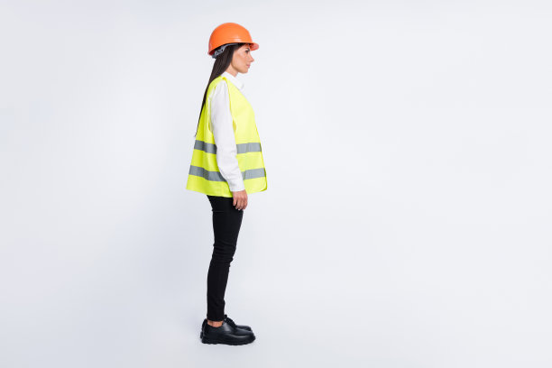 工匠女士的头像照片，穿着头盔、衬衫、背心、裤子和鞋子，背景为白色，显得空旷。图片下载