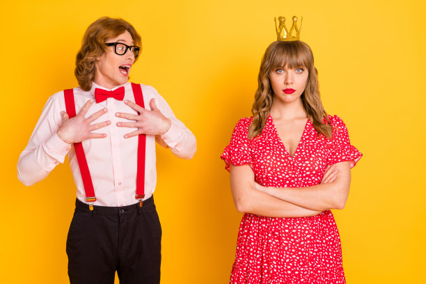 有趣的极客与严肃女孩约会时惊讶而着迷的照片肖像，背景为鲜艳的黄色。图片下载