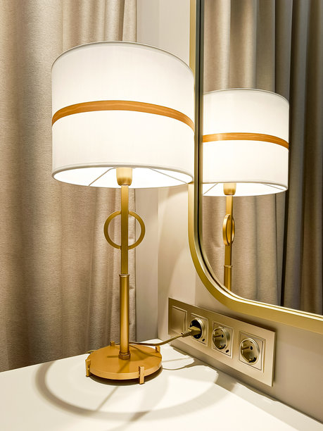 现代时尚的台灯放在床头柜上。人造光源。美丽的室内，特写。竖版照片。图片下载