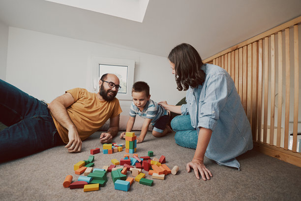 父母和他们的儿子在小卧室里玩耍的真实生活照片。微型房屋概念。图片下载