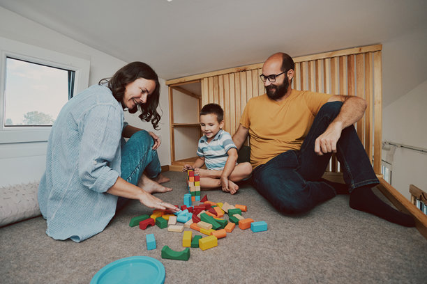 父母和他们的儿子在小卧室里玩耍的真实生活照片。微型房屋概念。图片下载