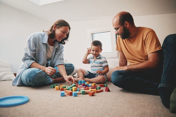 父母和他们的儿子在小卧室里玩耍的真实生活照片。微型房屋概念。图片下载