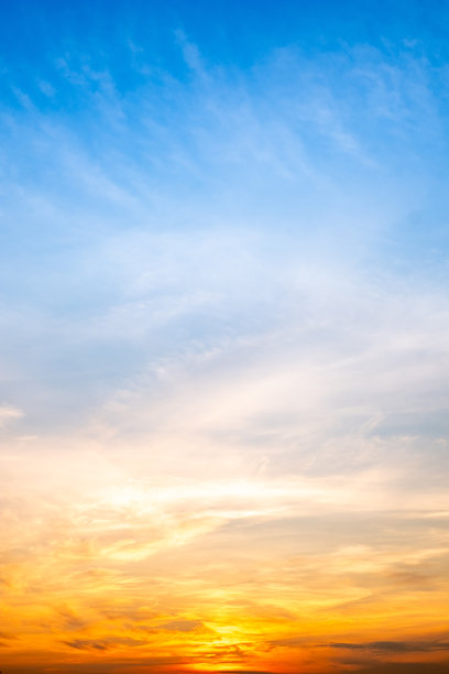 美丽奢华的柔和渐变橙金色云彩和阳光映照在蓝天上，适合用作背景，拍摄于傍晚黄昏，超大尺寸，高分辨率风景照片，竖版。图片下载