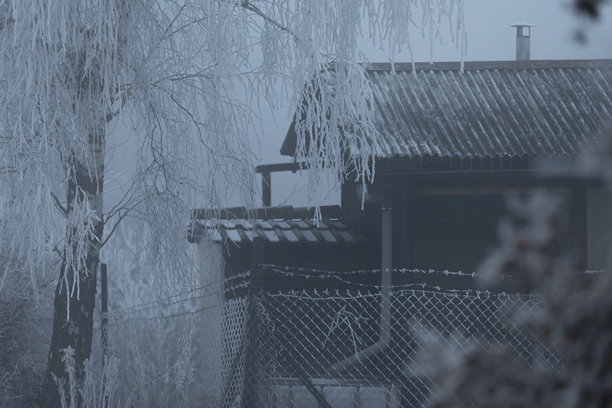 一张令人惊叹的黑白照片，展示了一座挂着冰柱的房子图片下载