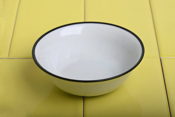 美丽的复古搪瓷碗在黄色瓷砖表面上的展示照片图片下载