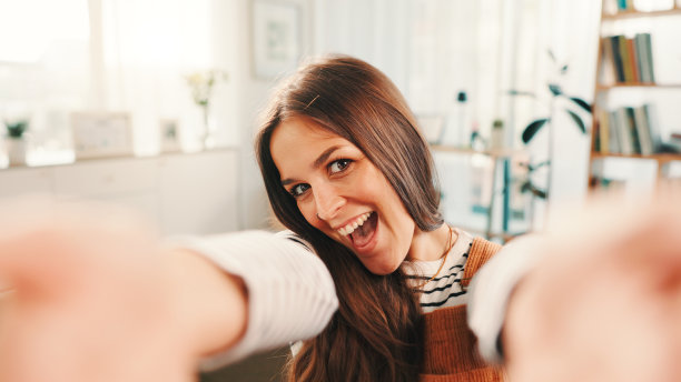 兴奋的女性在家中自拍和肖像，享受周末的放松、平静和休息，适合社交媒体。快乐、自信的女性在家中的客厅拍摄个人资料照片。图片下载