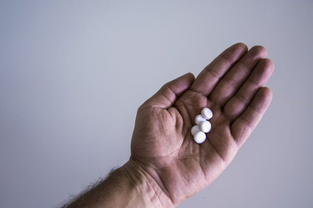 男人手握营养补充剂，健康生活方式或不健康生活方式的概念照片。图片下载