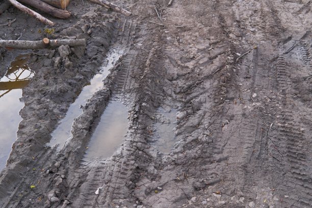 汽车或卡车在泥泞的田野或雨后有水坑的土路上留下的轮胎痕迹。恶劣天气驾驶的概念。季节性驾驶。车辆在不同天气条件下的越野能力。图片下载