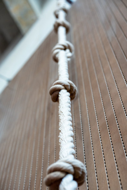 木质背景上的白色绳索与结，海洋装饰细节，竖版照片图片下载