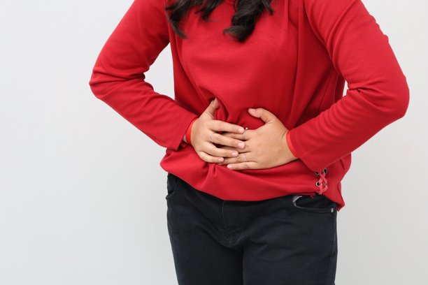 女人站着捂着肚子，肚子疼的概念，独立于白色背景的特写照片。图片下载