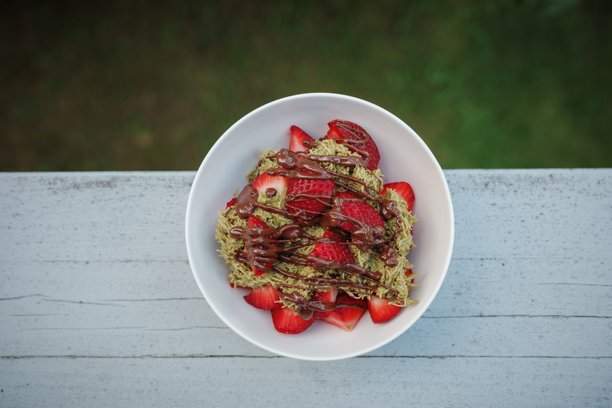 自制的迪拜巧克力草莓甜点，配有卡塔伊菲、开心果酱、牛奶巧克力和新鲜草莓。俯视图，竖版照片。街头食品甜点和糖果。文本留白。图片下载
