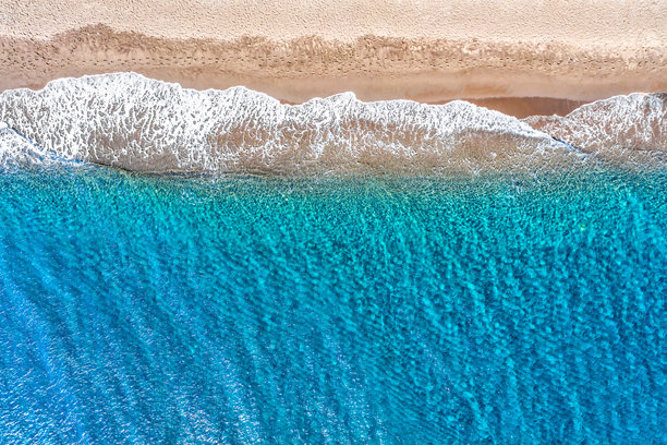 佩里萨海滩的鸟瞰无人机照片，展现了美丽的碧绿色海水和海浪。度假旅行背景。爱琴海，圣托里尼岛，希腊图片下载