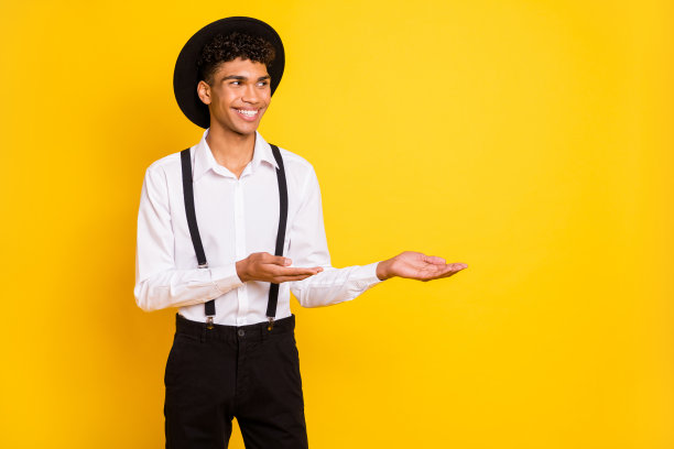 非洲裔美国男性在鲜艳的黄色背景下用双手展示空白空间的照片肖像图片下载