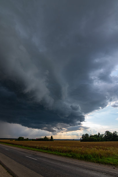 天气 垂直图片 田野和乡村道路上方的戏剧性黑色雨云图片下载