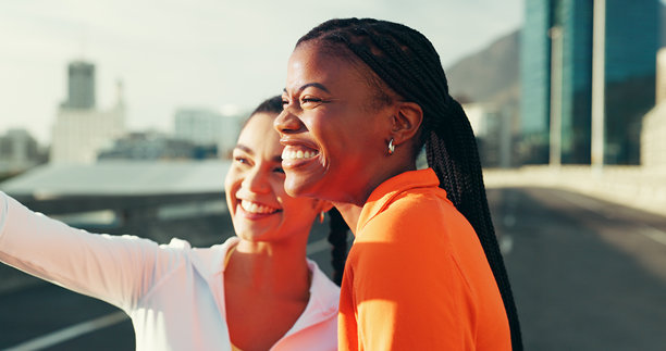 健身、朋友和快乐的女性在城市中自拍，适合社交媒体发布，与运动影响者一起。照片、微笑和户外跑步团队在街上拍摄，记录美好回忆或共同建立联系，促进健康。图片下载