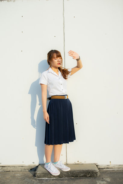 在一个精美布置的白色调环境中，一位年轻的亚洲女学生摆姿势拍摄可爱的照片，她优雅的亚洲风格在这张难忘的肖像中永远被定格。图片下载