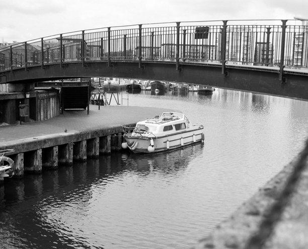 复古照片：一只小船停靠在码头的桥下图片下载