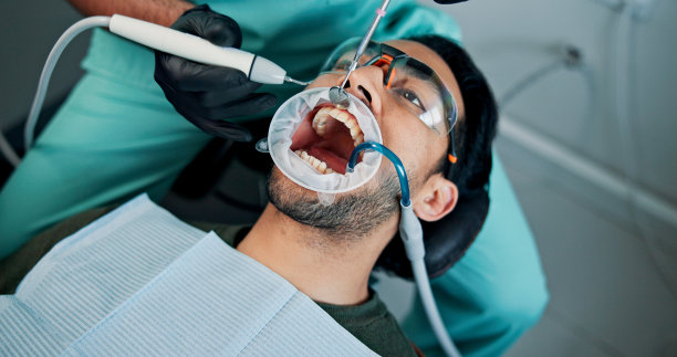 牙科诊所中进行的清洁、男性或口腔手术程序，针对牙痛、贴面和医疗手术。预约、手术或患者在口腔检查中接受牙科、牙齿美白和美容治疗。图片下载