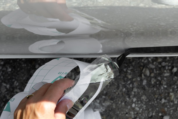 在车身上粘贴自粘贴纸，撕掉车上的广告。图片下载