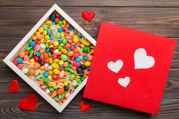 情人节构图：甜蜜的糖果，带有蝴蝶结的礼品盒和红色毛毡心形，照片模板，背景。俯视图，留白空间。图片下载