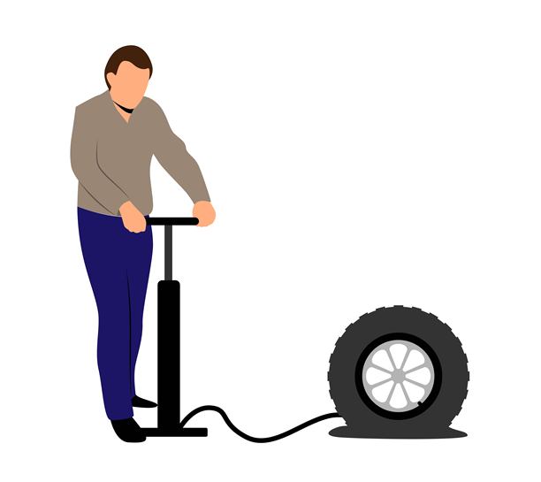 男子在白色背景下给一个瘪掉的轮胎充气图片下载