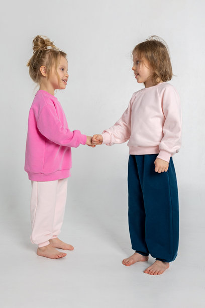 两个可爱搞笑的女孩在玩耍，享受乐趣。孩子们面带微笑，表情搞笑，背景明亮。竖版照片图片下载